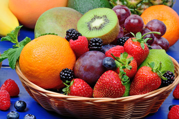 Mix of colorful fruits in a basket on table