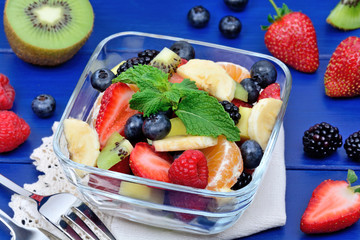 Colorful fruit salad in a bowl on a wood table