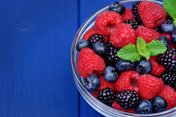 Fresh berries in a bowl on wooden table