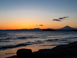 Mt. Fuji from the seaside at dusk. The mountain in the back is Mt. Fuji in Japan.The beachfront is very beautiful. In addition, the sunset is also very beautiful.