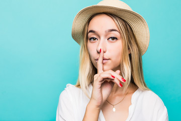 Close up portrait of a young woman showing silence gesture isolated over blue background