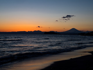 Mt. Fuji from the seaside at dusk. The mountain in the back is Mt. Fuji in Japan.The beachfront is very beautiful. In addition, the sunset is also very beautiful.