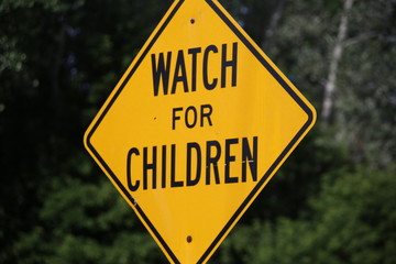 A Bright Yellow and Black Watch for Children Sign