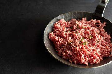 Frying-pan with raw minced meat in close up