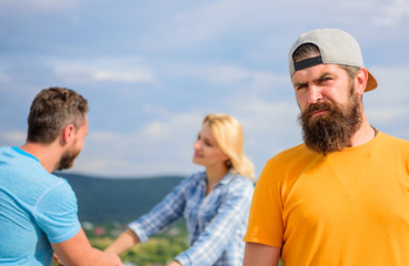 Obraz premium Guy adult still lonely while friends happy family life. No romantic in his life. Hipster sad face in front of couple in love. Man hipster feels lonely couple dating behind him. Unlucky romantic life