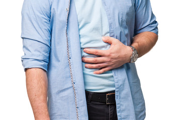 A man holds his hand to the stomach from pain or hunger or overeating, isolate on a white background
