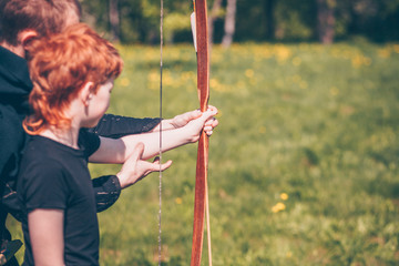 Archer teaches a red-haired boy archery