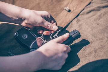 Fototapeta premium The boy performs disassembly, cleaning and assembly of the Makarov pistol