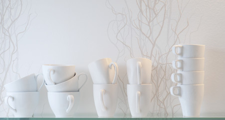 Multiple coffee or tea cups on a glass shelf in a clean, white and modern Scandinavian kitchen