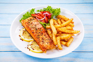 Fried salmon, French fries and vegetables 