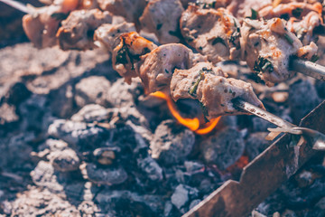 Pork meat is fried on an open fire in a hike