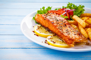 Fried salmon, French fries and vegetables 