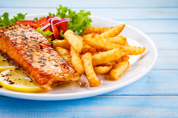 Fried salmon, French fries and vegetables 