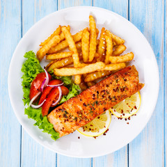 Fried salmon, French fries and vegetables 