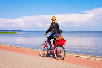 Woman riding bicycle Nida resort in Curonian Spit Baltic Sea