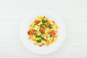 Italian pasta with tomatoes and pesto sauce, top view