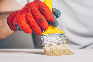 Painter performs paintwork - brushing primer on the surface
