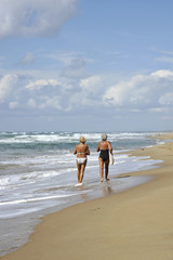 Two elderly women walking and talking on the beach. Sabaudia, Lazio, Italy