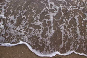 the shore of the sea wet sand with a wave of clear water