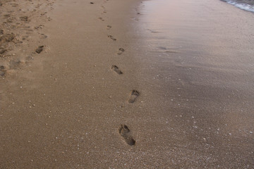 Fototapeta na wymiar Footprints on the sand on the coast