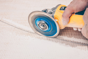 Finishing works - the tiler curvilinearly cuts the tile