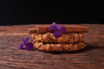 Closeup on stack of chocolate Chip ion wood background with live flowers - cookies for mom on...