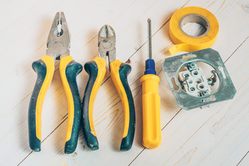 A set of electrician tools - pliers, side cutters, screwdriver, electrical tape, electrical outlet
