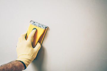 Finishing works - first person view - the master grinds the wall, copyspace