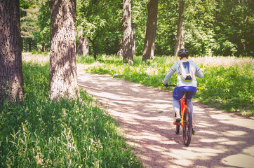 Naklejka premium Cyclist in helmet on orange bike riding in park
