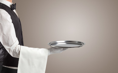 Waiter serving with white gloves and steel tray in an empty space
