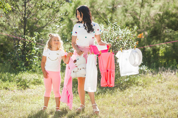 Obraz premium Cute little girl and her mother laundring