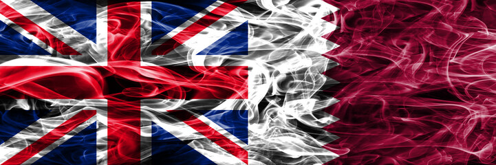 United Kingdom vs Qatar smoke flags placed side by side. Thick colored silky smoke flags of Great Britain and Qatar