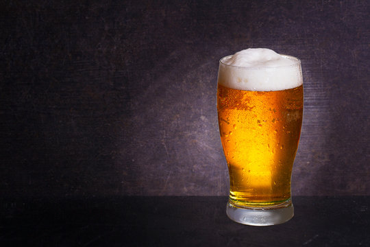 Glass of beer on wooden background with copyspace for text