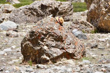 Forgotten hat on a stone with a human face at the foot of mount Kailash, Kailas. Tibet, China