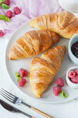 Breakfast with croissants, tea, confiture and berries on white background