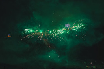 Awesome couple of green fireworks on the feast of the patron saint of the city whose church is visible in the background, Vittorio Veneto, Italy