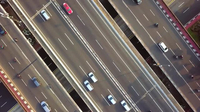 Rotating aerial view of rush hour traffic on a busy road.