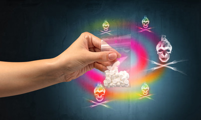 Female hand delivers illegal capsules with death s head wallpaper