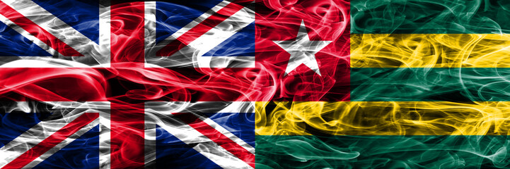 United Kingdom vs Togo smoke flags placed side by side. Thick colored silky smoke flags of Great Britain and Togo