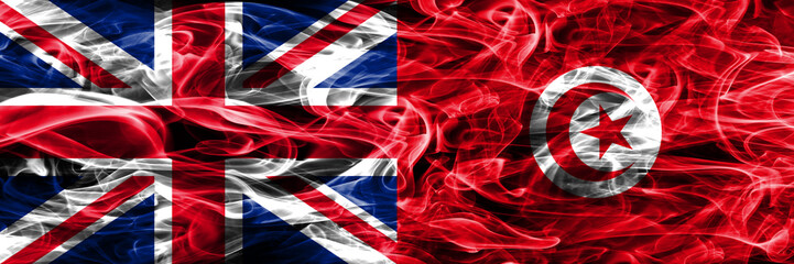 United Kingdom vs Tunisia smoke flags placed side by side. Thick colored silky smoke flags of Great Britain and Tunisia