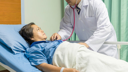 Doctor visits old female patient at her patient room