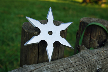 Shuriken (throwing star), traditional japanese ninja cold weapon stuck in wooden background