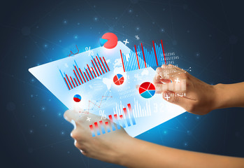 Young female hand holding a tablet with red and blue charts