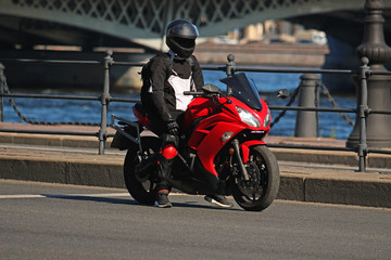 motorcyclist on a red motorcycle stopped on the road