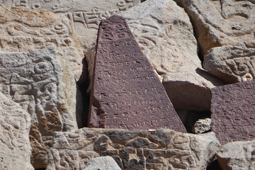 Древние тибетские письмена на камнях в горах на высоте более 5000 метров над уровнем моря