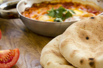 Fresh pita bread with Shakshuka - fried eggs with tomato,red pepper and spices