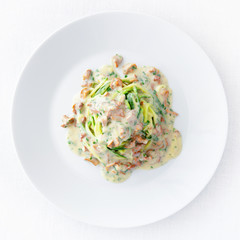 parboiled zucchini spaghetti under white sauce with chanterellas and parsley