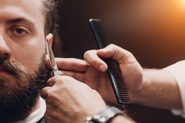 Barbershop with wooden interior. Bearded model man and barber.