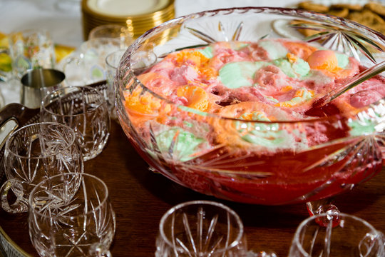 Crystal Bowl Full of Colorful Sherbet Punch with Punch Glasses Around It