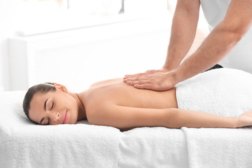 Relaxed woman receiving back massage in wellness center